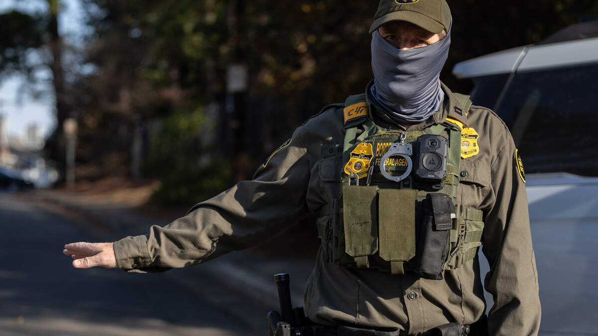 A Border Patrol Agent keeps watch while other agents make an arrest on Sharonbrook Drive in Charlotte on Sunday morning, Nov. 16, 2025.
