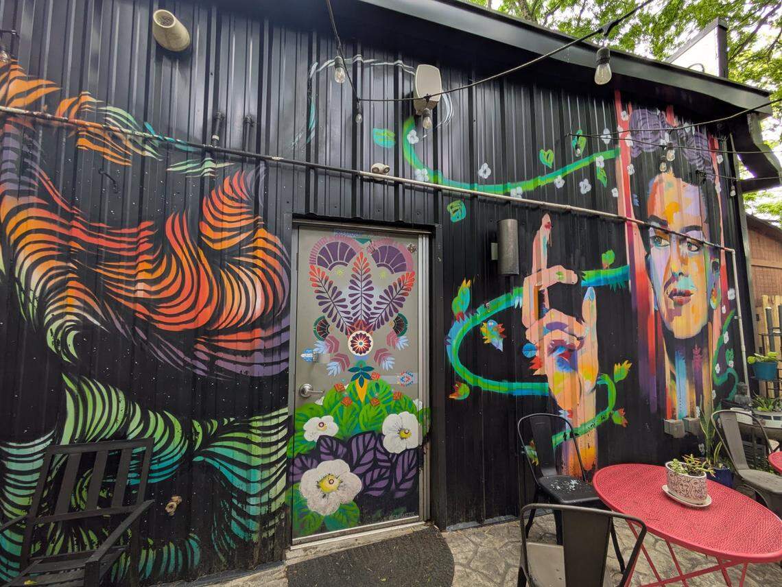 The rear patio at Artisan’s Palate features a collaborative mural by Charlotte artists Sam Guzzie, Owl, Georgie Nakima and Dakotah Aiyanna.