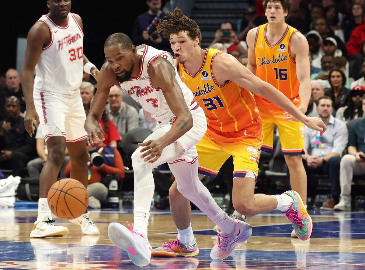 Houston Rockets forward Kevin Durant, left, chases after a loose ball with Charlotte Hornets forward Tidjane Salaun, right, during Thursday’s action at Spectrum Center.