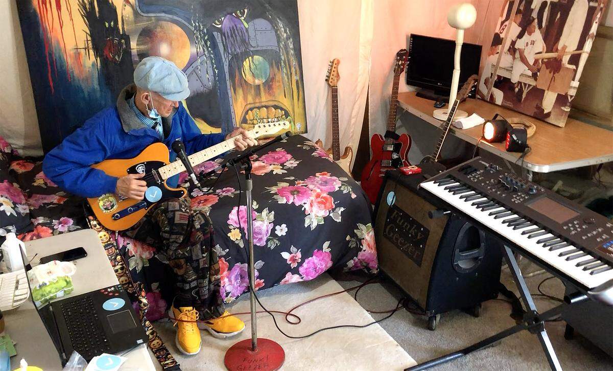Woody Williams noodles on his guitar in the tiny, funkily decorated room where he records the majority of his TikTok videos.