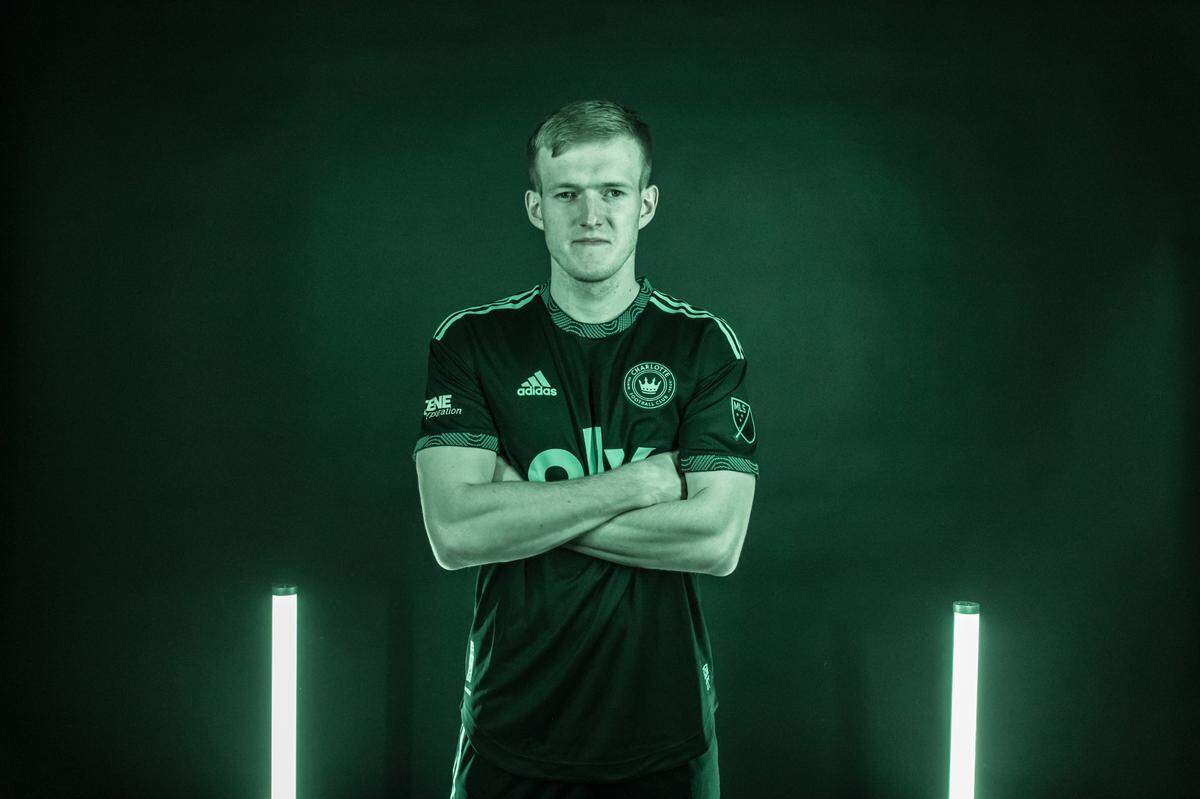 Charlotte FC striker Karol Świderski poses in the secondary kit that Charlotte FC players will wear during the team’s first Major League Soccer seasons.
