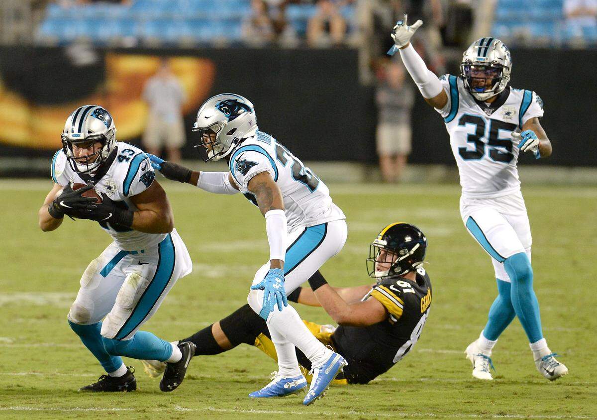Carolina Panthers linebacker Jordan Kunaszyk, left, gets up and runs for yardage after intercepting a Pittsburgh Steelers pass Thursday. Kunaszyk, an undrafted rookie free agent, made the Panthers’ 53-man roster over Labor Day weekend.