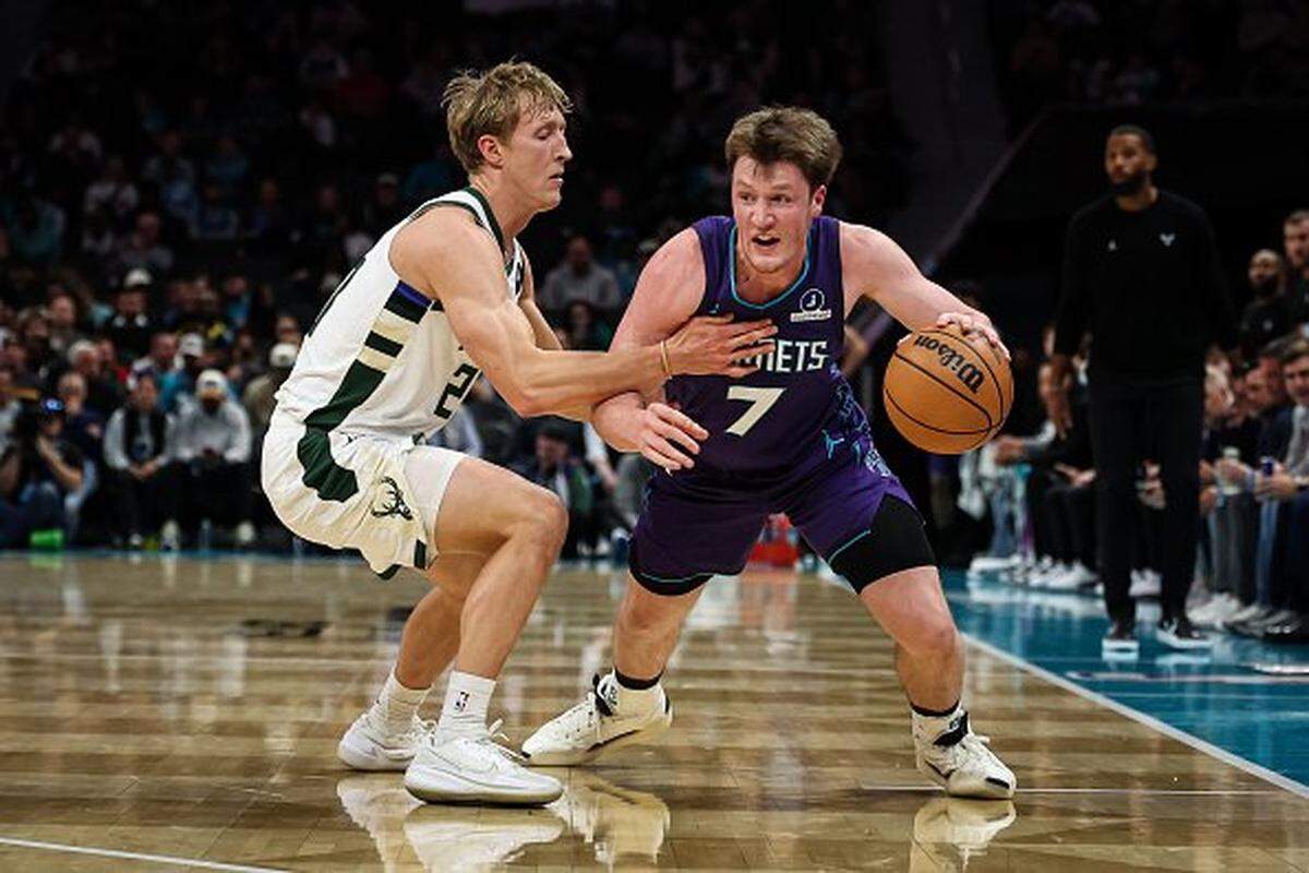 Kon Knueppel (7) of the Charlotte Hornets drives by AJ Green of the Milwaukee Bucks during the first half at Spectrum Center on Nov. 12, 2025 in Charlotte, North Carolina.