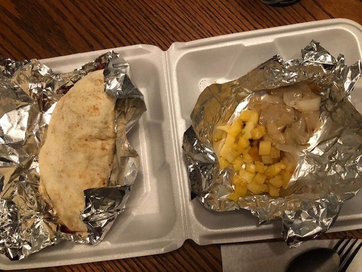 The Gringa at Tacos El Regio is a flour tortilla is filled with marinated pork and melted cheese served with grilled pineapple and onion.