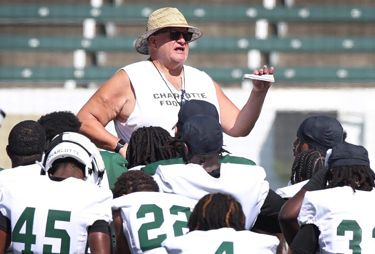 Charlotte 49ers head coach Biff Poggi, center, speaks to the team following their first summer training camp practice on Friday, August 3, 2024.