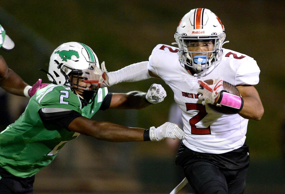 South Meck Sabres running back Jacob Newman, right, pushes Myers Park Mustangs Cam Thornton, left, to the side on a run during second quarter action on Friday, October 22, 2021 at Myers Park High School.