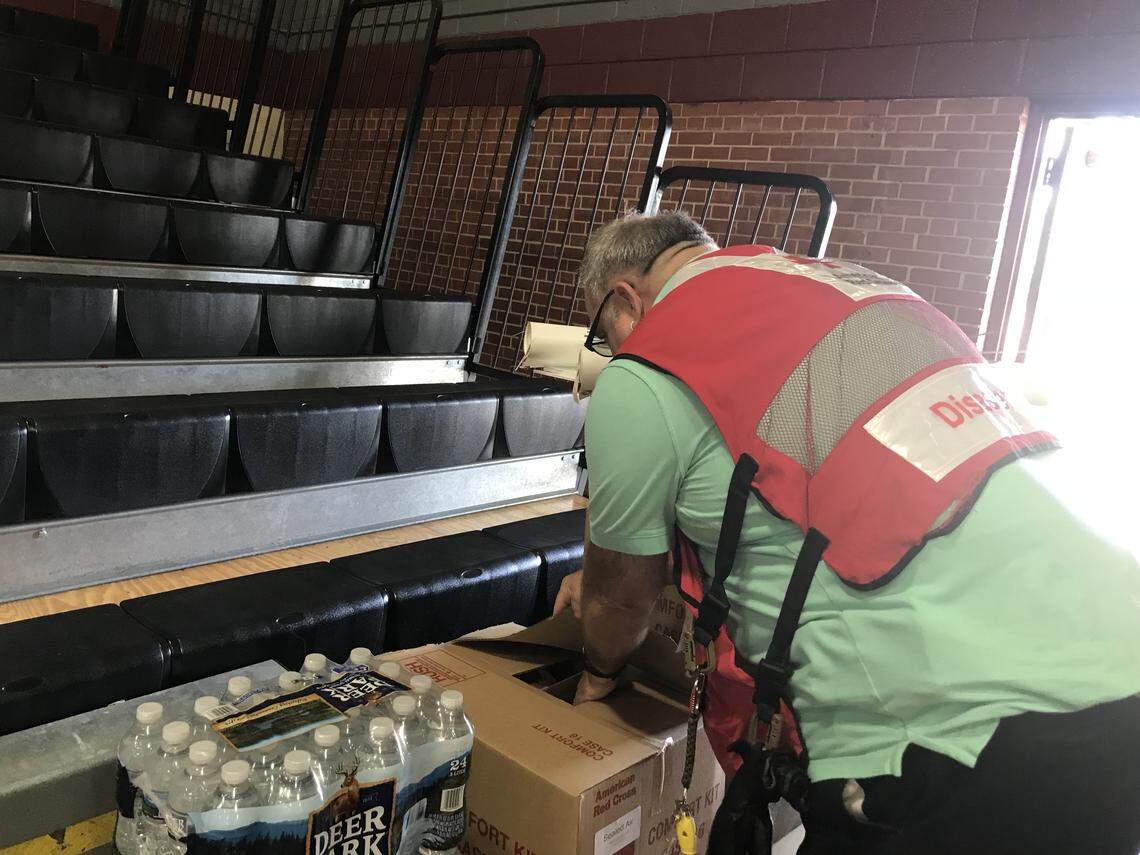 Kristjan Rahe opening a box of “comfort kits” full of toiletries for shelter guests evacuating from Florence’s path.