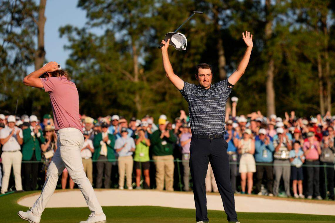 Cameron Smith, of Australia, walks past as Scottie Scheffler celebrates after winning the 86th Masters golf tournament on Sunday, April 10, 2022, in Augusta, Ga. (AP Photo/Matt Slocum)
