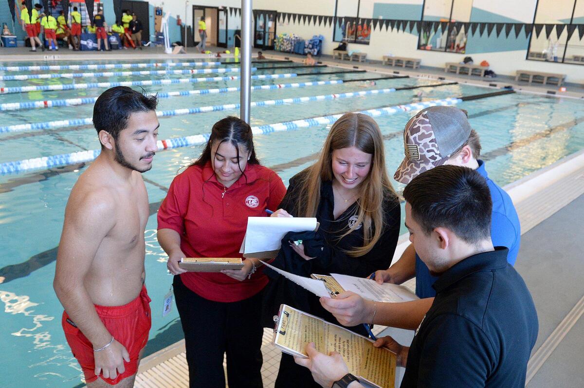 (L to R) Angel Cabrera Paulino, 20, Angelica Cabrera, 23, Sabrina Husketh, 19, Peyton Mincey, 21 and Juan Gutierrez, 25, begin gathering clues, some underwater, to a “murder” mystery at Eastway Regional Recreation Center. A Mecklenburg County Park and Recreation department program entitled, Aquatic Mystery Solvers, gathered Aquatic Recruiting Team members to test drive the program on Saturday, Dec. 07, 2024. The program is open to folks ages 14-99, wishing to sharpen their in-water skills while finding clues, to the mystery.