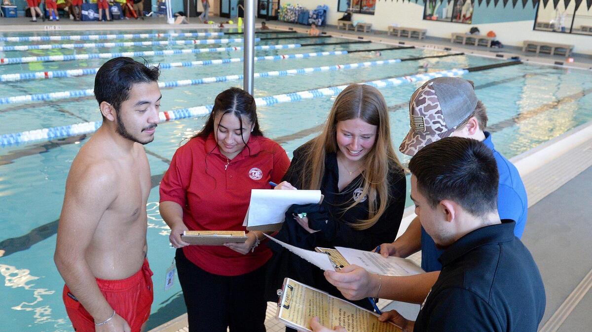 (L to R) Angel Cabrera Paulino, 20, Angelica Cabrera, 23, Sabrina Husketh, 19, Peyton Mincey, 21 and Juan Gutierrez, 25, begin gathering clues, some underwater, to a “murder” mystery at Eastway Regional Recreation Center. A Mecklenburg County Park and Recreation department program entitled, Aquatic Mystery Solvers, gathered Aquatic Recruiting Team members to test drive the program on Saturday, Dec. 07, 2024. The program is open to folks ages 14-99, wishing to sharpen their in-water skills while finding clues, to the mystery.