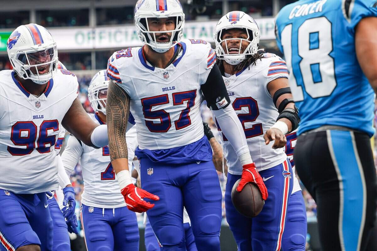 Bills defensive end A.J. Epenesa, center, celebrates an interception of a pass by Panthers quarterback Andy Dalton, intended for wide receiver Jalen Coker during the game at Bank of America Stadium in Charlotte, NC on Sunday, October 26, 2025. The Bills defeated the Panthers, 40-9.