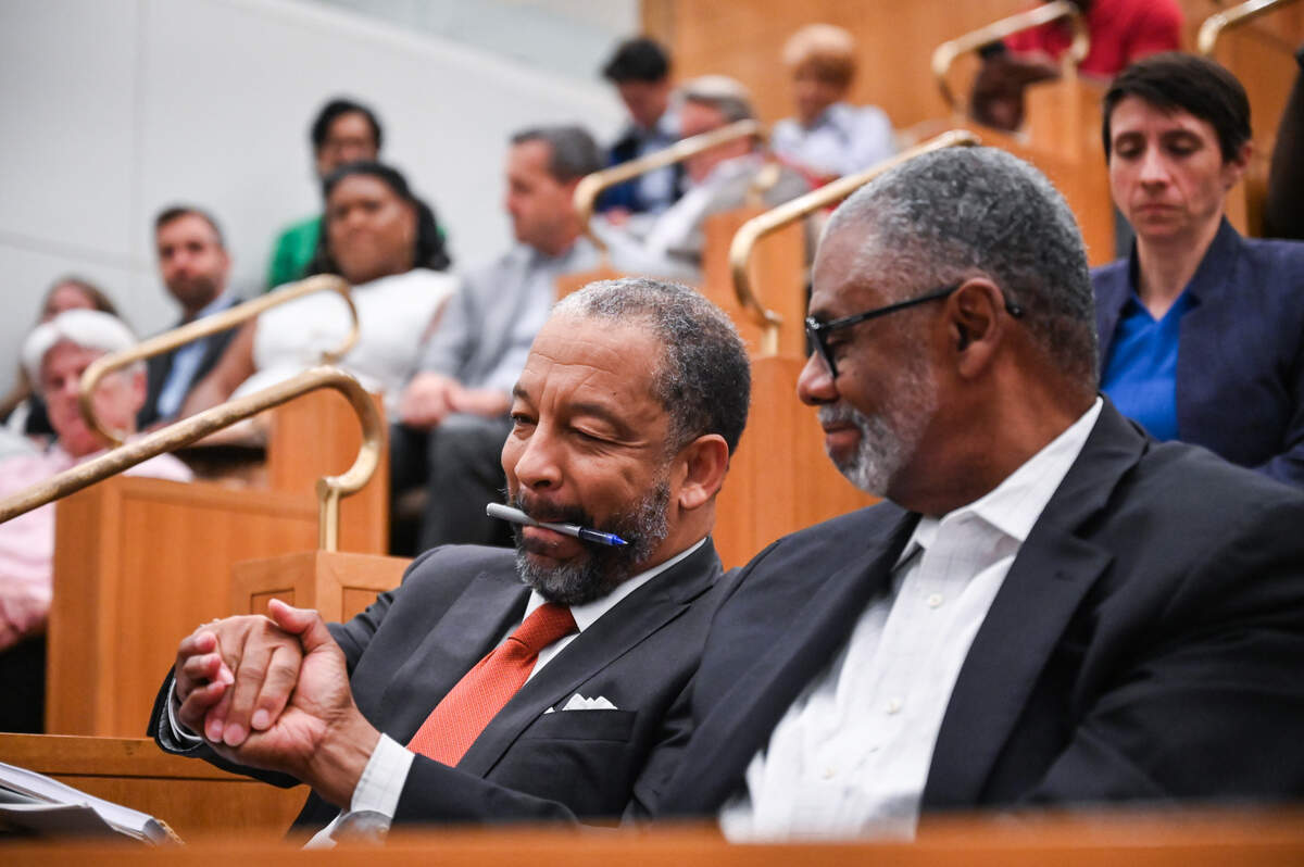 Robert Harrington, left, gets a congratulatory handshake Monday evening after being named interim mayor of Charlotte. Harrington, an attorney, will finish out the term of Mayor Vi Lyles, who plans to retire next week.