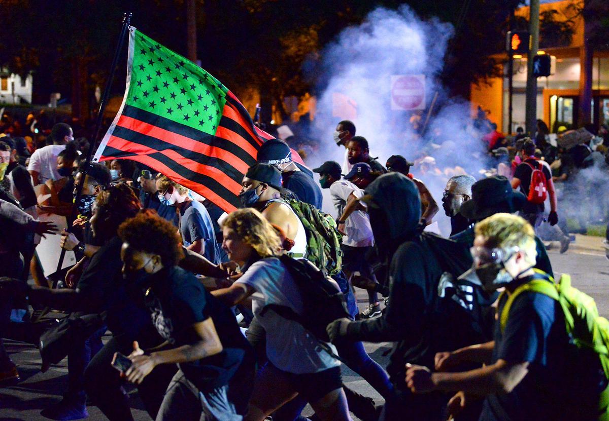 Protesters scatter as CMPD releases flash bangs and pepper balls at the intersection of 5th Street in Charlotte, NC on Tuesday, June 2, 2020.