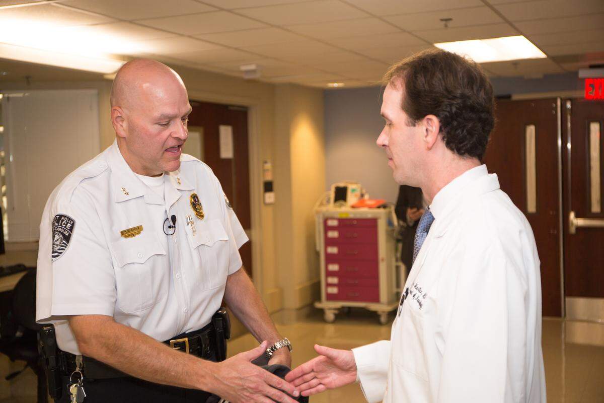 Police Chief Don Roper of Mt. Holly, N.C., thanks Dr. Jerry Martin of Carolinas Medical Center/Atrium Health in Charlotte. Roper had a massive stroke on the job. Martin, a neurologist, helped save his life.