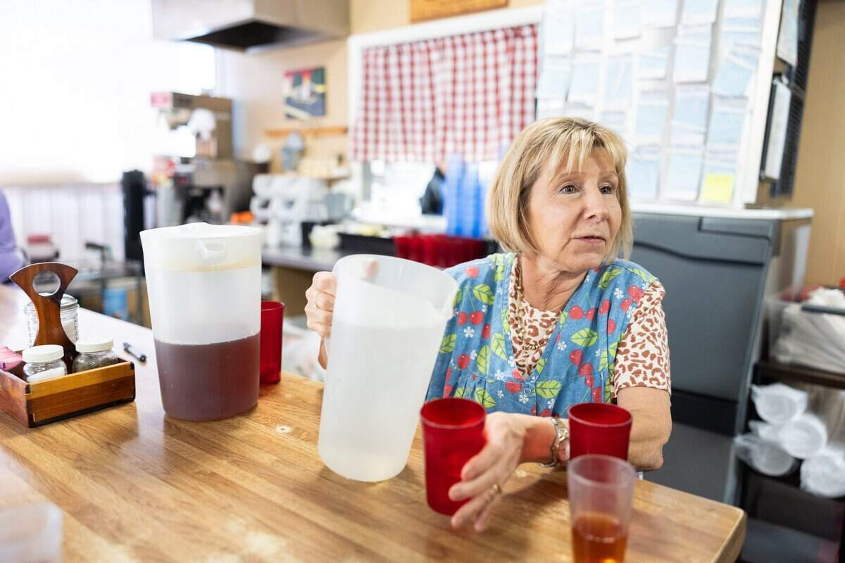 Julie Yawn, owner of Chat-n-Nibble, pours a glass of water for a customer.