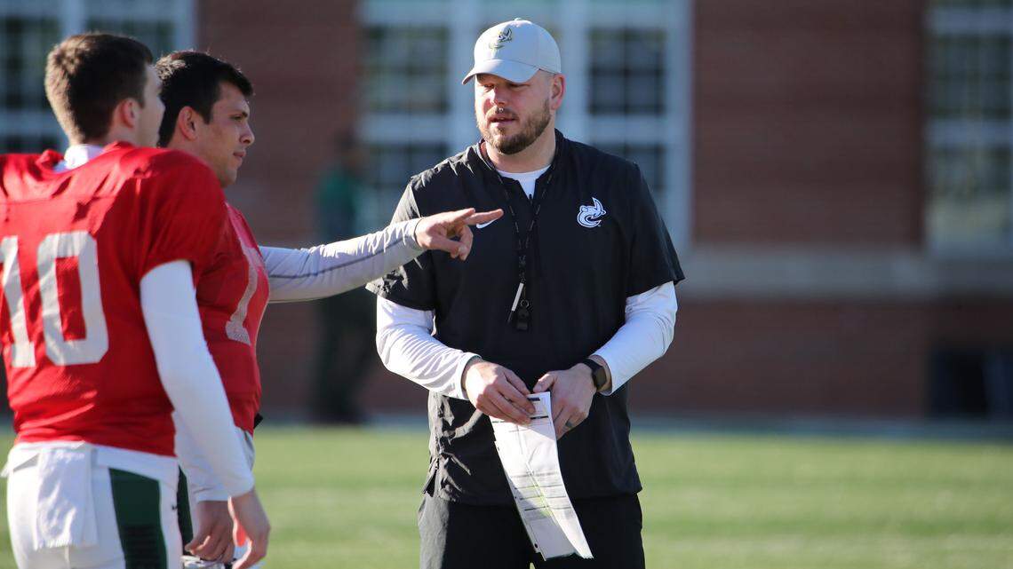 New Charlotte 49ers offensive coordinator Mark Carney (right) talks with quarterbacks Chris Reynolds (center) and Dylan Ratliff.