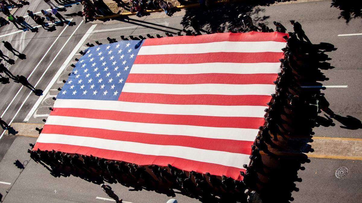 A huge American flag is carried down Sumter Street during the 35th Annual Veterans Day Parade in Columbia, S.C., Monday, Nov. 11, 2013. Storms with bouts of “heavy rain” could soak the Charlotte area into the July 4 weekend, 2021, according to the National Weather Service. Dry conditions are expected Sunday and Monday, July 4 and 5.