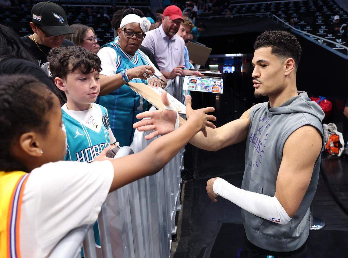Charlotte Hornets guard Josh Green, right, slaps hands with a fan Tuesday at Spectrum Center before the team’s play-in tournament game against the Miami Heat.