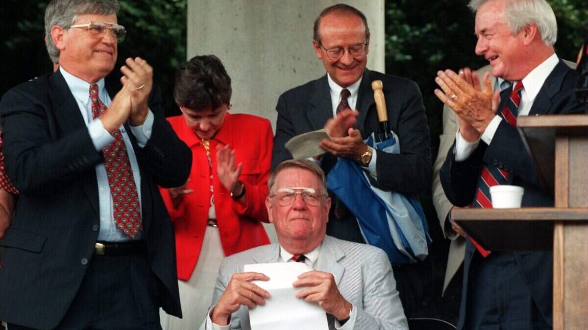Former Gov. Jim Martin (left) and Gov. Jim Hunt (right) applauded Seddon "Rusty" Goode Jr. after a new stretch of Interstate 485 from Interstate 77 to N.C. 49 was named for him in 1997.
