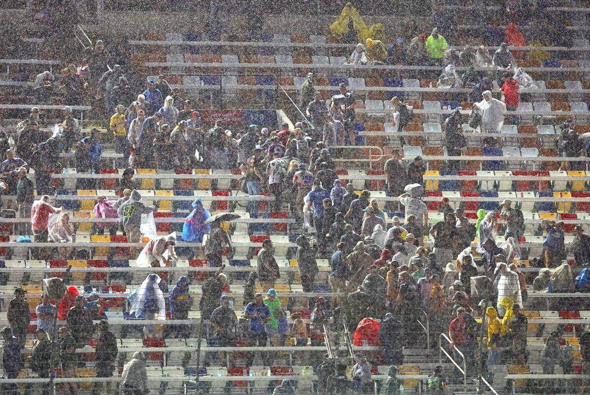 NASCAR fans head for the exits as rain falls in the closing moments of the Coca-Cola 600 at Charlotte Motor Speedway in Concord, NC on Sunday, May 24, 2026. Driver Daniel Suarez would be declared the winner when the race was stopped due to rain.
