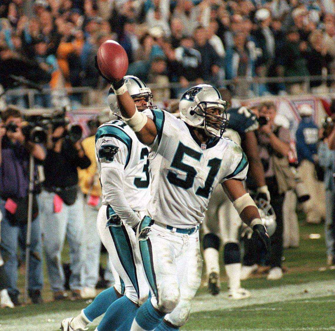 Sam Mills shows the ball to the crowd following an interception against Dallas in the 1996 playoffs.