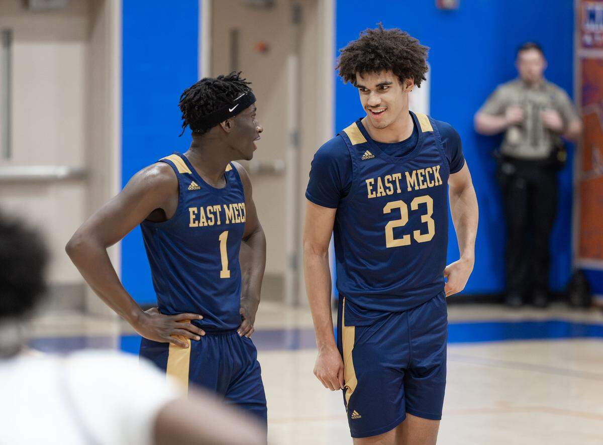 East Meck's Jordan Buzzard (23) Nixon Wright (1) have a conversation coming out of a 2nd quarter timeout. West Meck Men's basketball team would take on East Meck at the Phenom Hoops Mike Gminski Classic at Marvin Ridge High School December 27, 2025.
