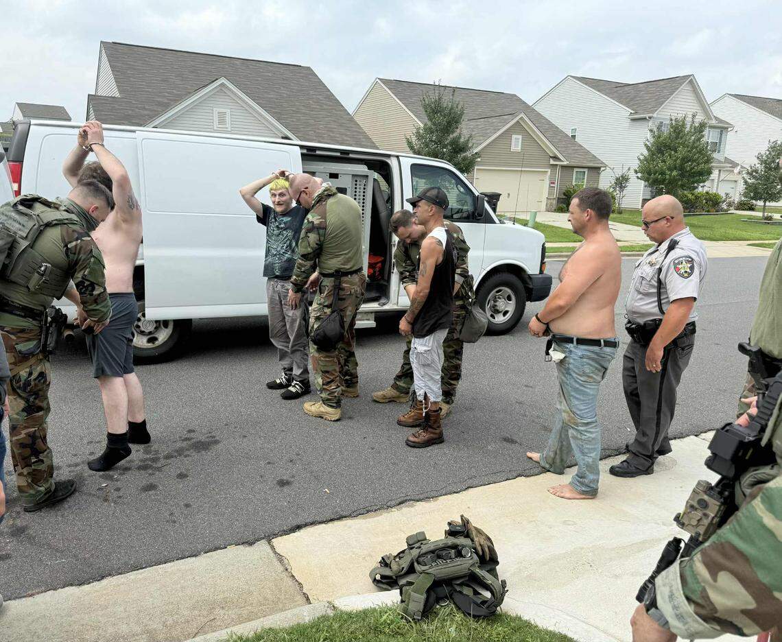 Iredell County deputy sheriffs perp walk people arrested during an Aug. 8 drug bust in Statesville. Several used a piece of cloth to conceal their identities.