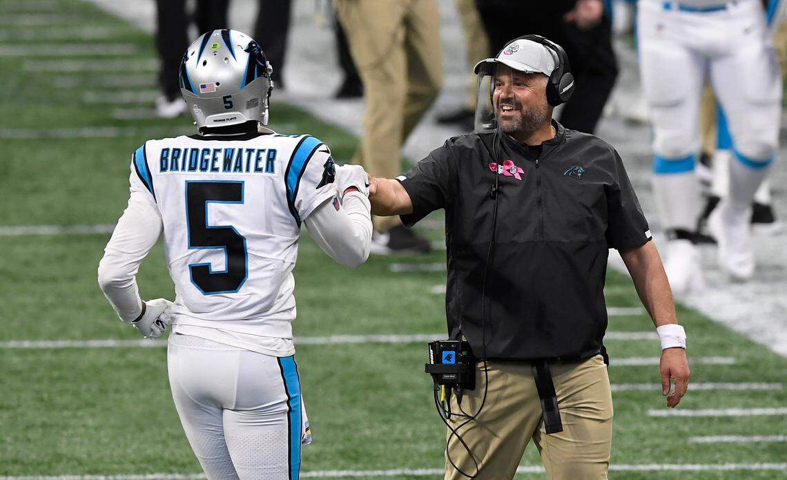 Carolina Panthers head coach Matt Rhule fist-bumps quarterback Teddy Bridgewater (5) during a timeout against the Atlanta Falcons at Mercedes-Benz Stadium in Atlanta in 2020. Rhule traded Bridgewater away after one season.