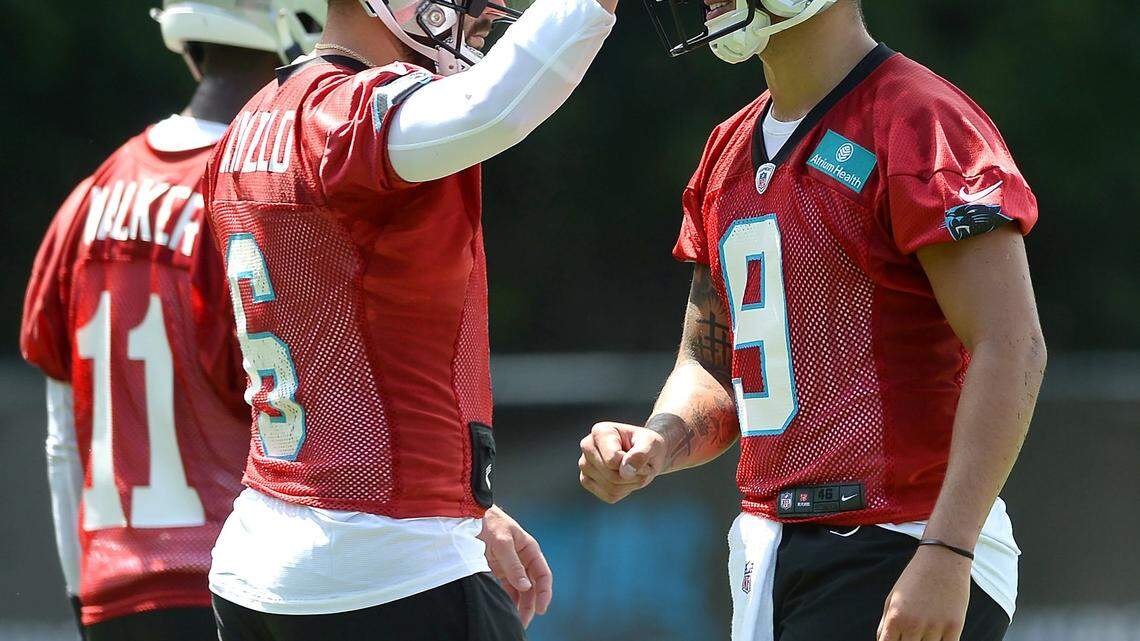 Carolina Panthers quarterback Baker Mayfield, left, pats the helmet of rookie quarterback Matt Corral, right, following a drill on Wednesday, July 27, 2022 at Wofford College in Spartanburg, SC.