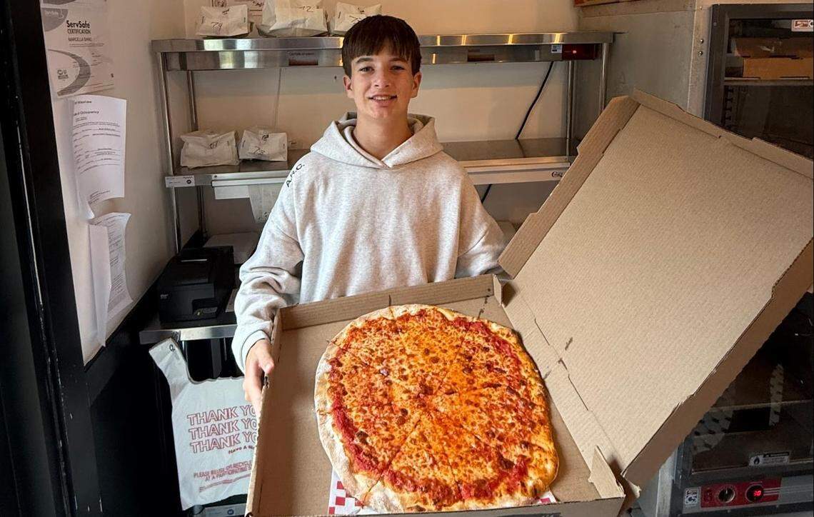 Tristan Graziano holds a pizza at Siano’s.