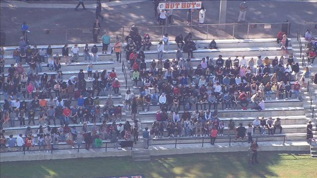 In this image from WSOC’s helicopter, students wait out an evacuation on the football stands at Northwest Cabarrus High School in Concord, NC, on Monday, September 19, 2022. School staff found a note with a bomb threat, forcing the evacuation.