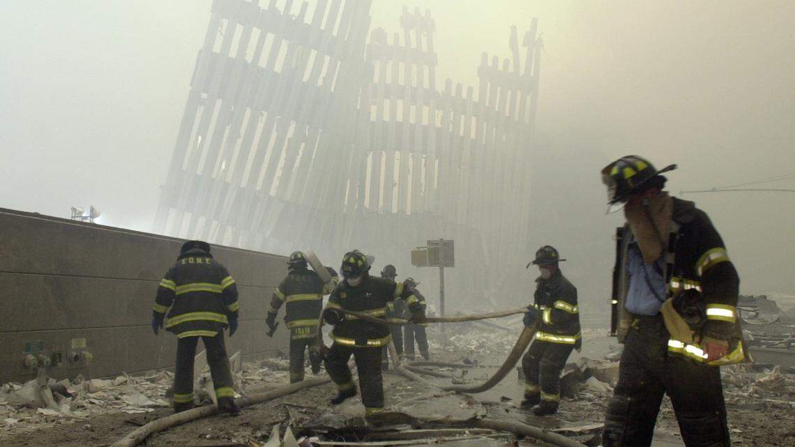 In this Sept. 11, 2001, file photo, firefighters work beneath the destroyed mullions, the vertical struts which once faced the soaring outer walls of the World Trade Center towers, after a terrorist attack on the twin towers in New York.