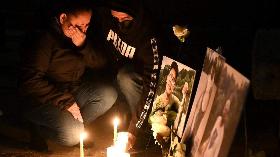 Iris Bonilla, left and Osman Reyes, right, kneel at a memorial for their son, Jose Canaca and two other men who died when a scaffolding collapsed on a construction site they were working at in early January 2023. The men fell 70 feet when the scaffolding collapsed. Family and friends gathered on Friday, February 3, 2023 at Marshall Park for a candle light vigil in memory of the three men.