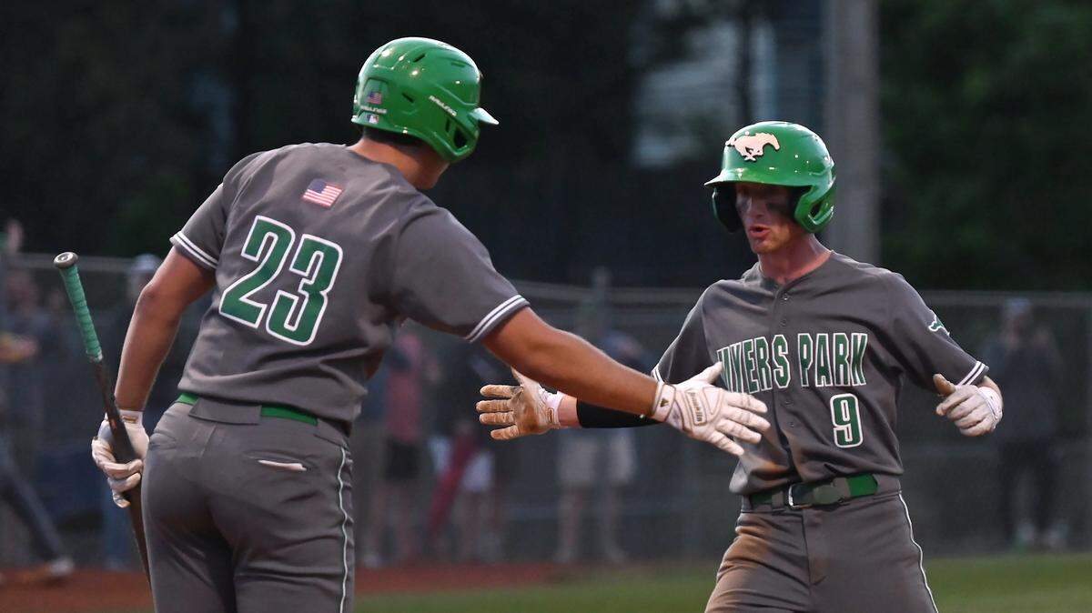 Myers Park Mustangs William Bryant, left, reaches out to congratulate teammate Reece Perry, right, as Perry scores a run against the Ardrey Kell Knights on Thursday, May 12, 2022. The Mustangs defeated the Knights 8-6 in NCHSAA second round baseball playoff action.