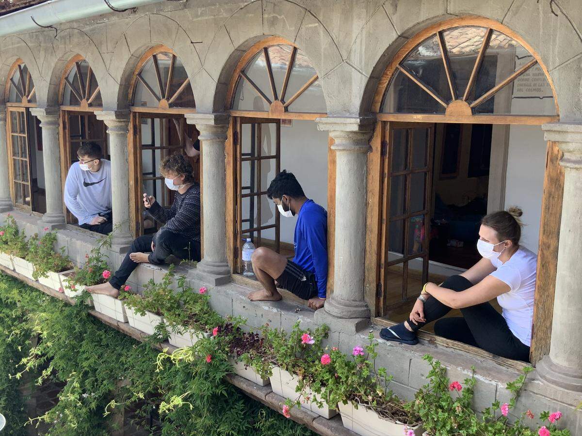 Pariwana Hostel guests gather around the courtyard to listen in on a meeting discussing quarantine procedures given by the Ministry of Health.
