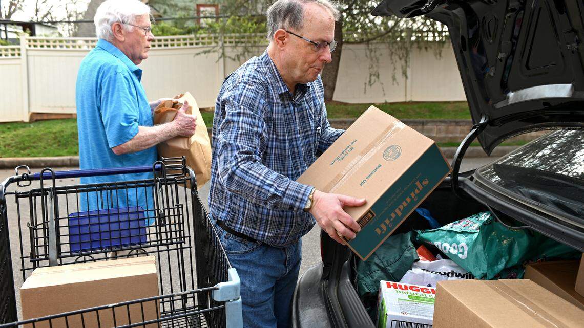 Loaves & Fishes volunteers Don Peeler, left and Gil Gaffney, right, load a clients car with groceries on Monday, February 27, 2023 at Holy Comforter Episcopal Church in Charlotte, NC. Loaves & Fishes/Friendship Trays have seen an explosion in need and are bracing for the end of increased snap benefits on Tuesday, February 28, 2023.