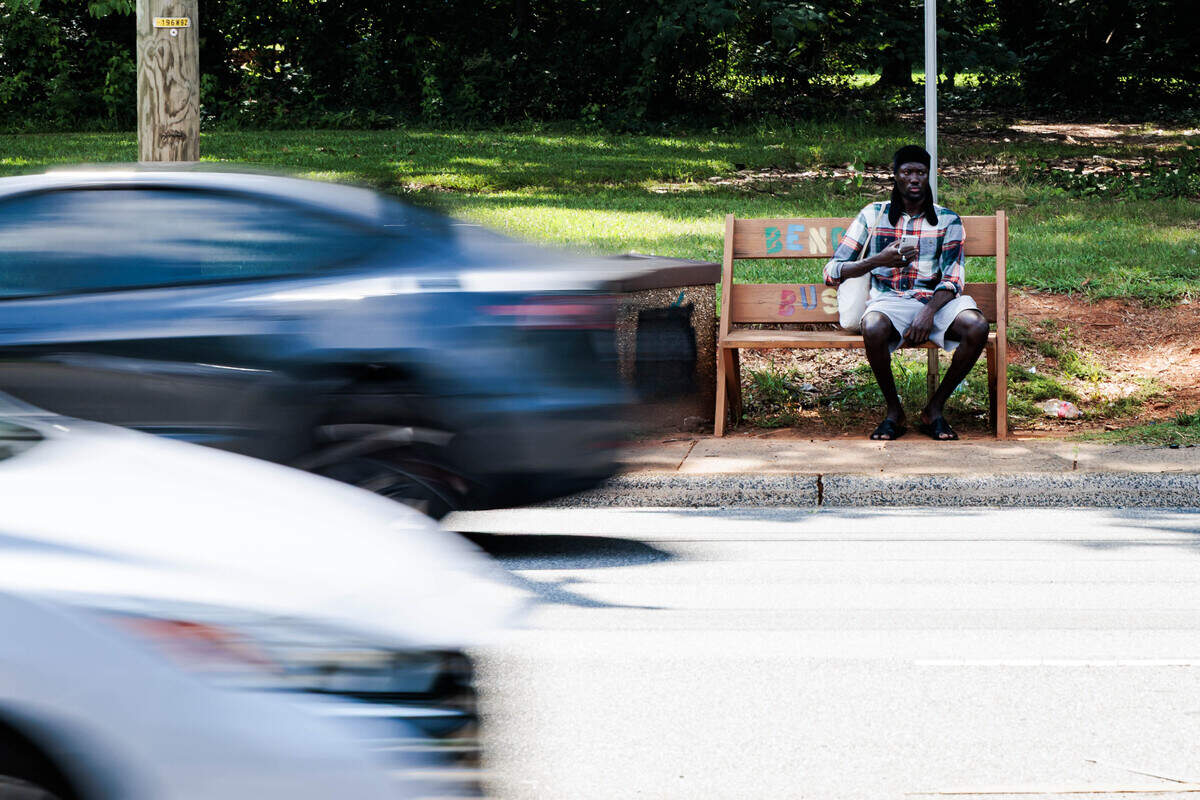 The bus stop near Hidden Valley on W. Sugar Creek Road on Tuesday, June 30, 2026. To access the stop, people must walk on a narrow sidewalk next to the bustling road.