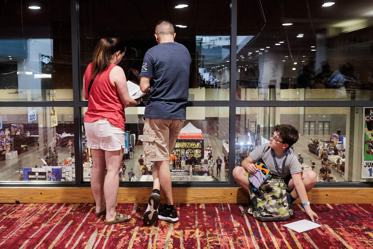 From left: Allison, Jody and Jonathan (13) Paite overlook Heroes Convention while flipping through the guidebook on Friday, June 12, 2026 at the Charlotte Convention Center. Jonathan Paite said the was excited to go around the convention and collect autographs.