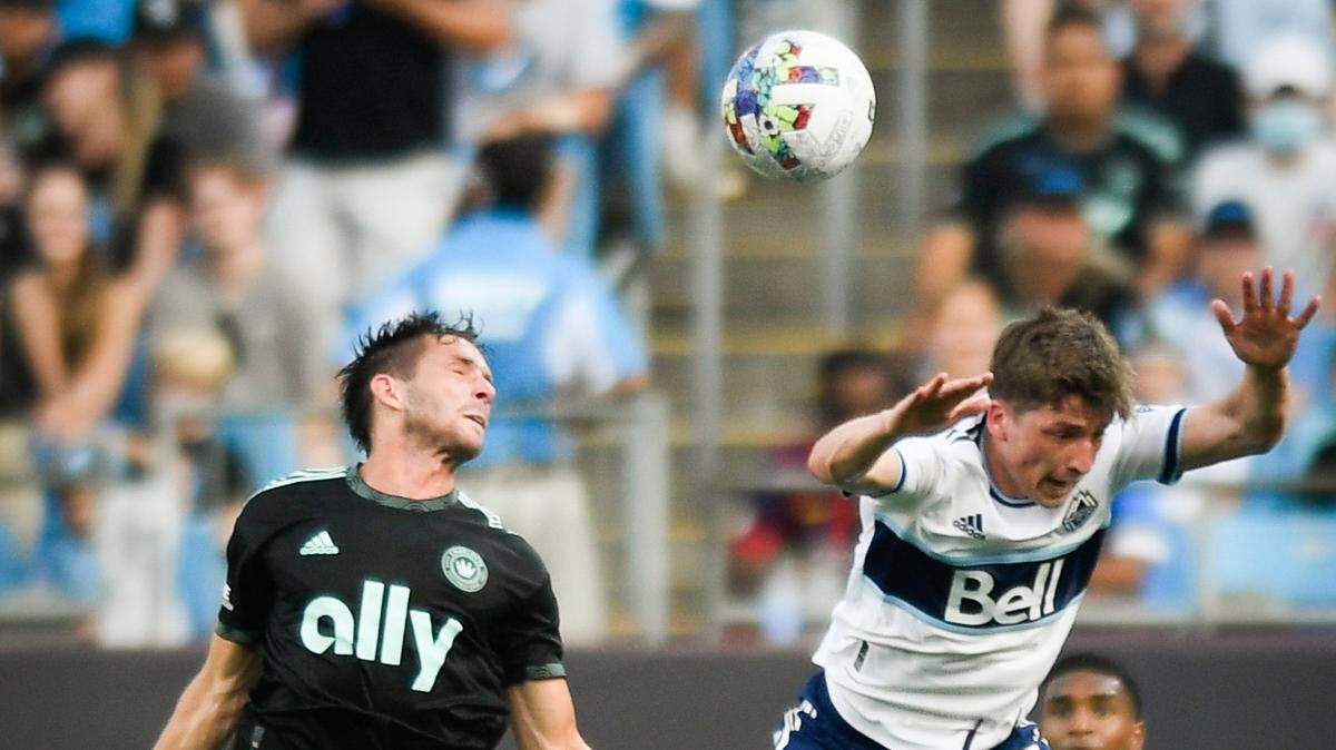 Charlotte FC midfielder Brandt Bronico (13) headers the ball over Vancouver Whitecaps midfielder Ryan Gauld (25) during a game at Bank of America Stadium in Charlotte, N.C., Sunday, May 22, 2022.