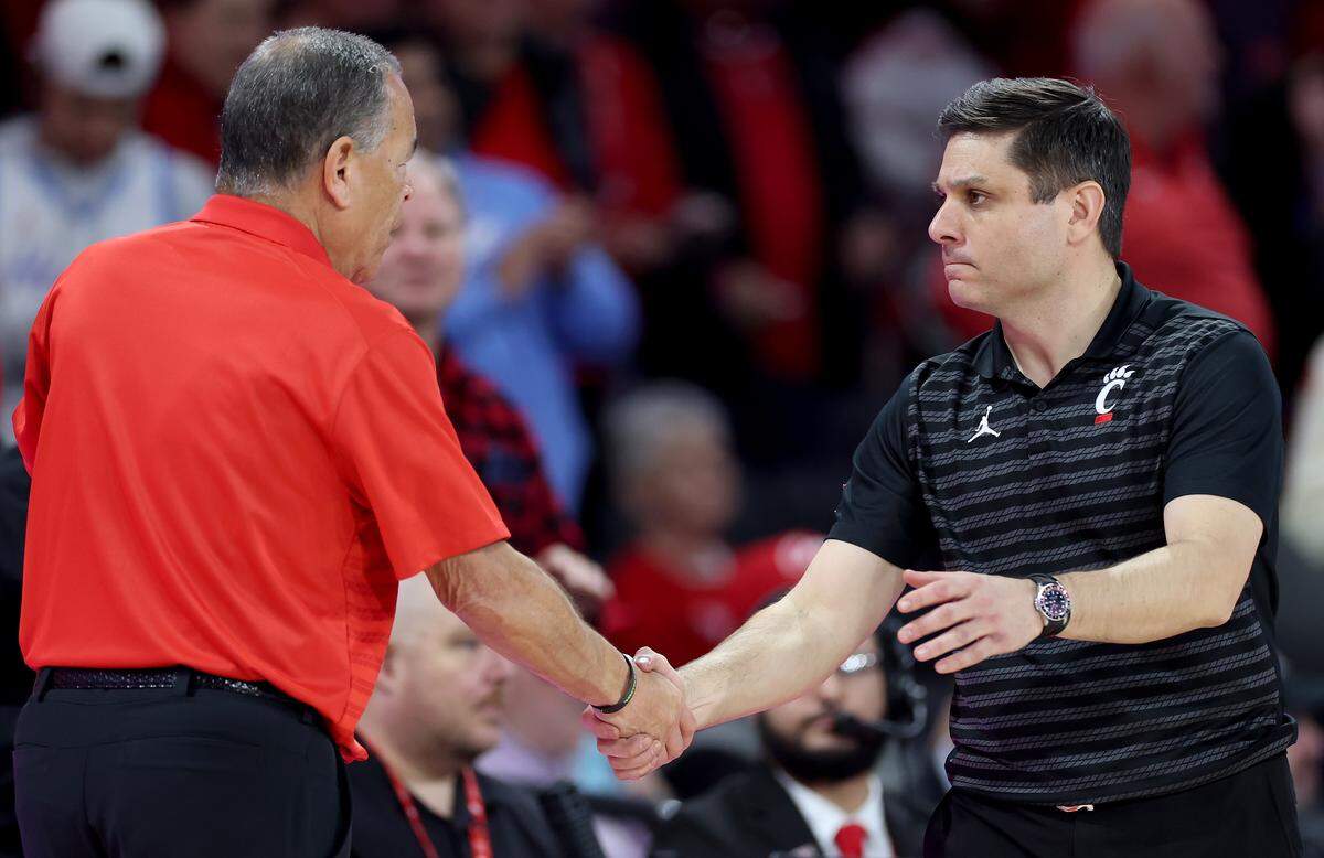 Then-Cincinnati Bearcats coach Wes Miller, right, shakes hands with Houston Cougars coach Kelvin Sampson after a January, 2026 game.