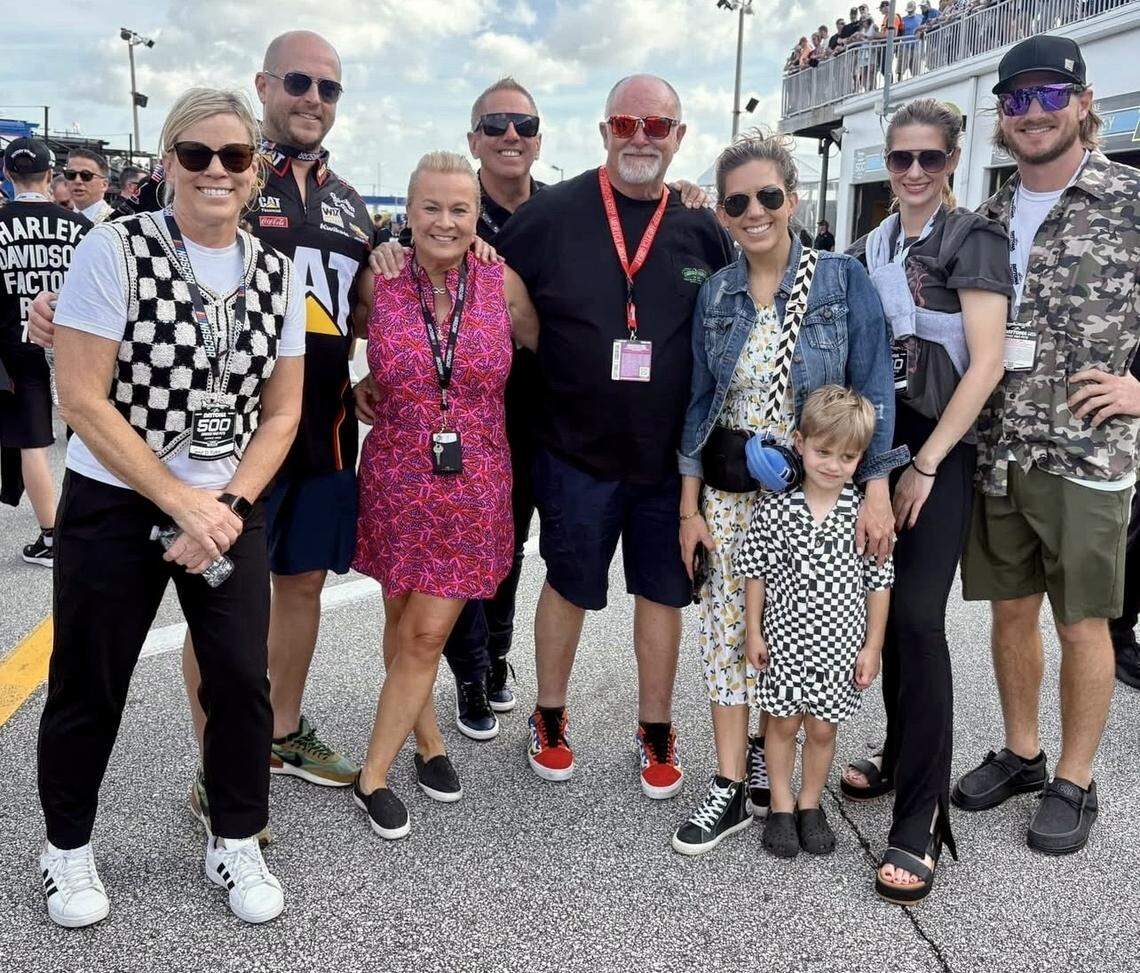 Craig Wadsworth, center, and Traci Hultzapple, left, take a photo at a NASCAR racetrack with members of the Biffle family, including former NASCAR driver Greg.