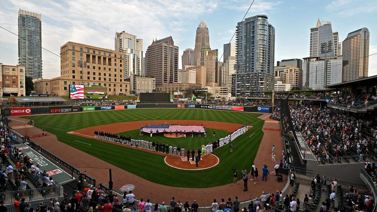 The Charlotte skyline provides the backdrop as fans stand for the national anthem at Truist Field in 2024.