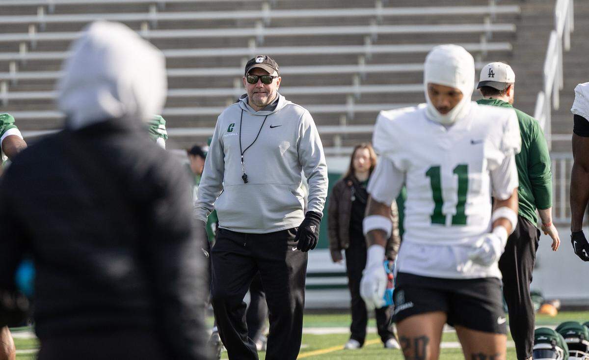 Charlotte 49ers coach Tim Albin watches players warm up during spring football practice at Jerry Richardson Stadium in Charlotte, North Carolina, on Tuesday, March 24, 2026.