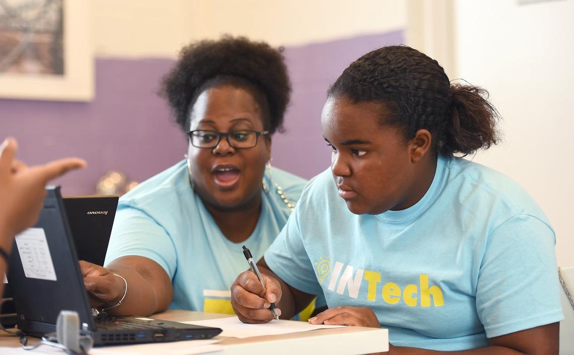 Jamie Lewis, technology mentor, helps INTech camper Erin Kirkpatrick, 10.