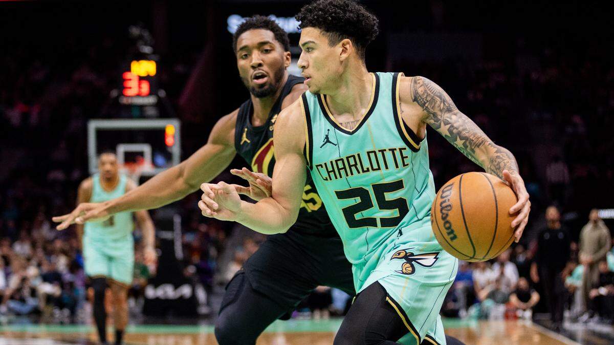 Dec 7, 2024; Charlotte, North Carolina, USA; Charlotte Hornets guard KJ Simpson (25) drives past Cleveland Cavaliers guard Donovan Mitchell (45) during the first quarter at Spectrum Center.