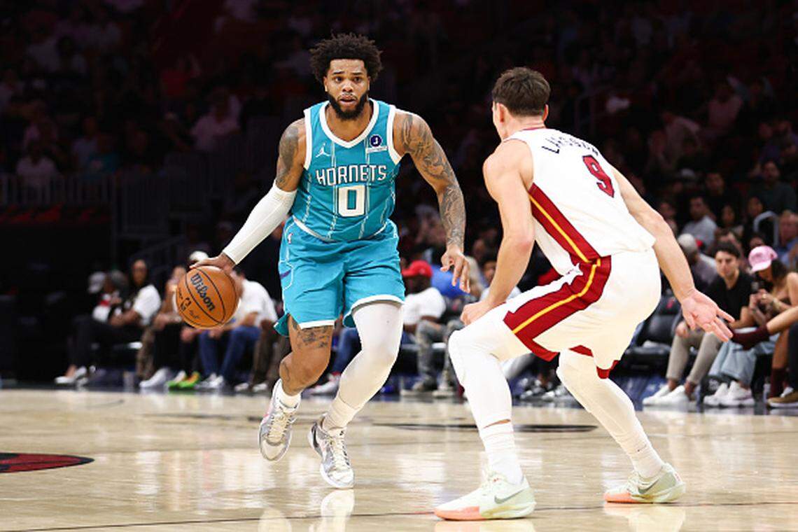Miles Bridges of the Charlotte Hornets dribbles the ball against Pelle Larsson of the Miami Heat during a game at Kaseya Center on October 28, 2025.