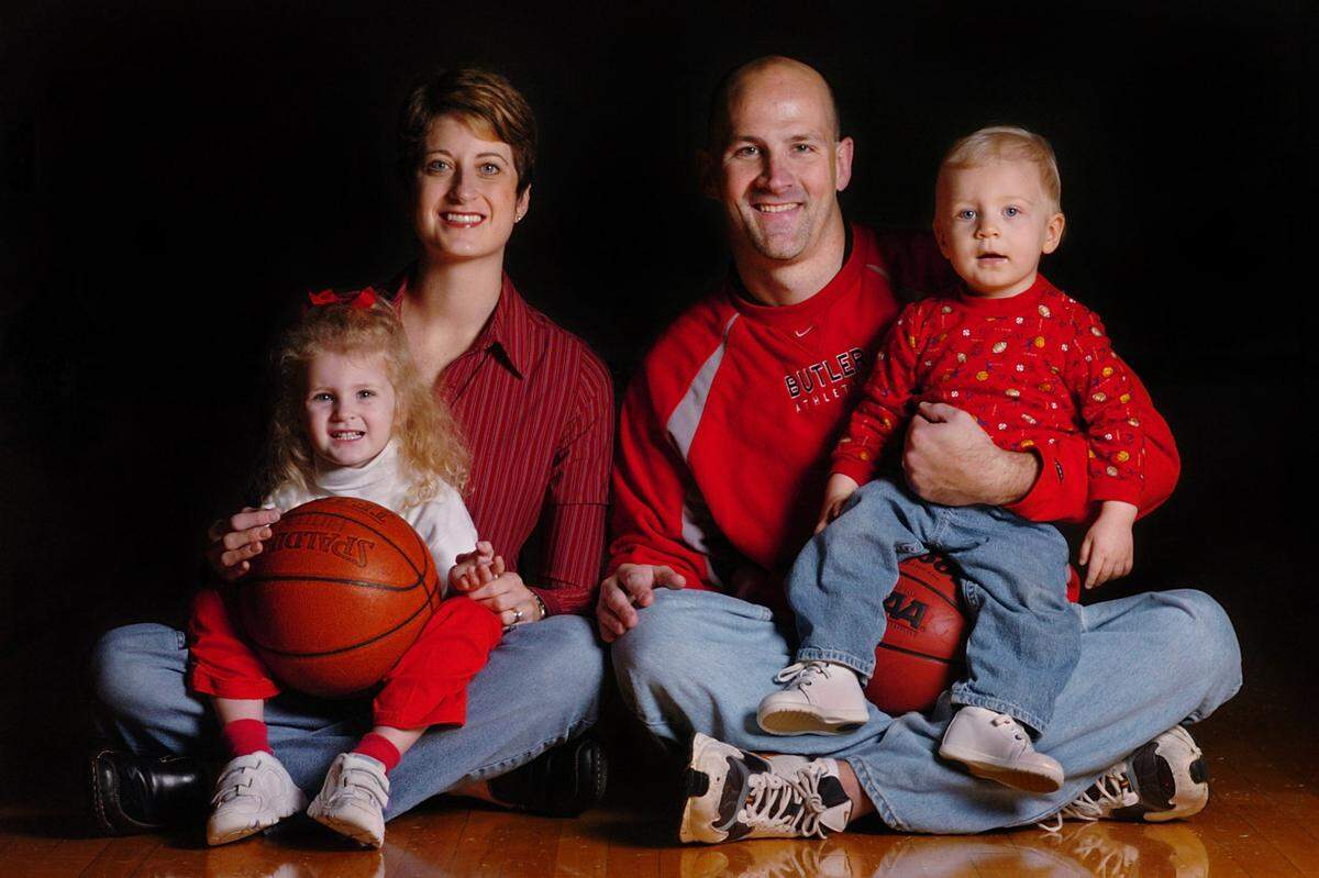 10/29/04: New Butler High boys basketball coach Kurt Wessler (CQ, from left decked out in Butler High colors, his wife Colleen Wessler,CQ, holds daughter Gianna Wessler, CQ, 3, while Kurt holds one-year-old son Patrick Wessler,CQ.) left a successful program at Vance, which won the state title two years ago, to take a job at a school that had two players and nine points returning. Wessler wanted to be closer to his family. His home is three minutes from Butler. Colleen was an all conference post player for Charlotte Catholic High School. Kurt played four positions from shooting guard to center for coach, Bob Angley, at Northwest Cabarrus High School. (JOHN D. SIMMONS/STAFF)
