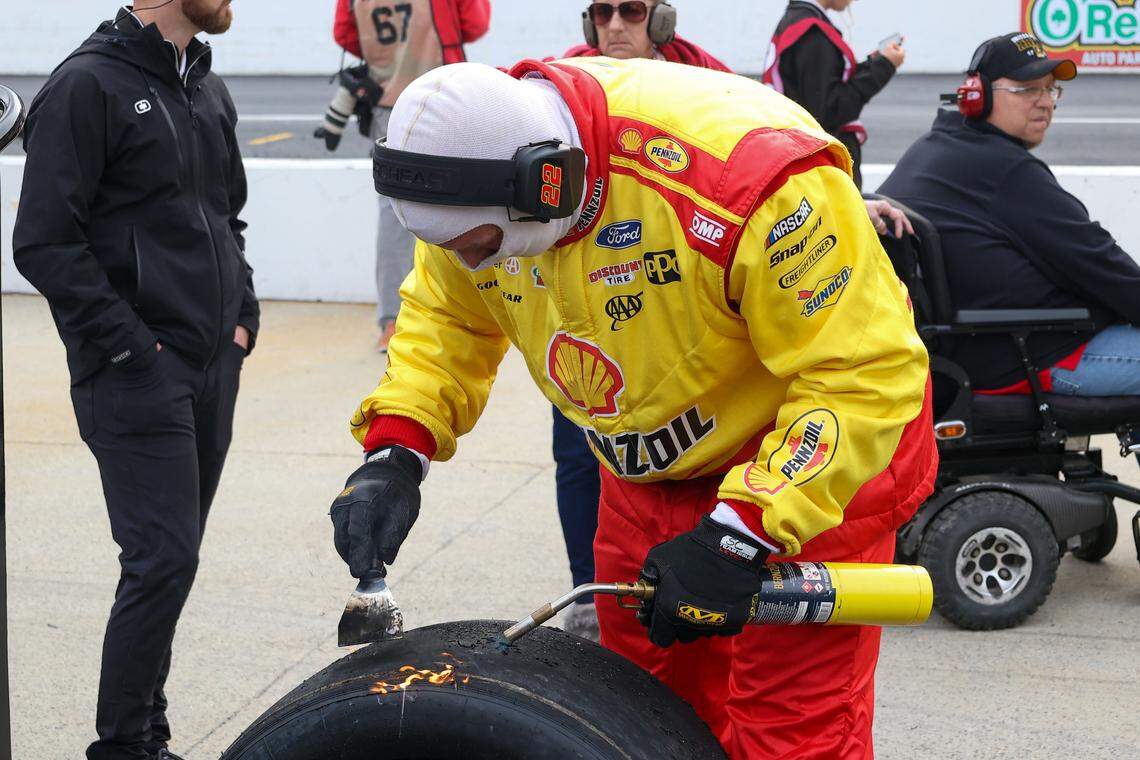 Mar 16, 2024; Bristol, Tennessee, USA; A crew member for NASCAR Cup Series driver Joey Logano (22) scrapes tires during the NASCAR Food City 500 at Bristol Motor Speedway.