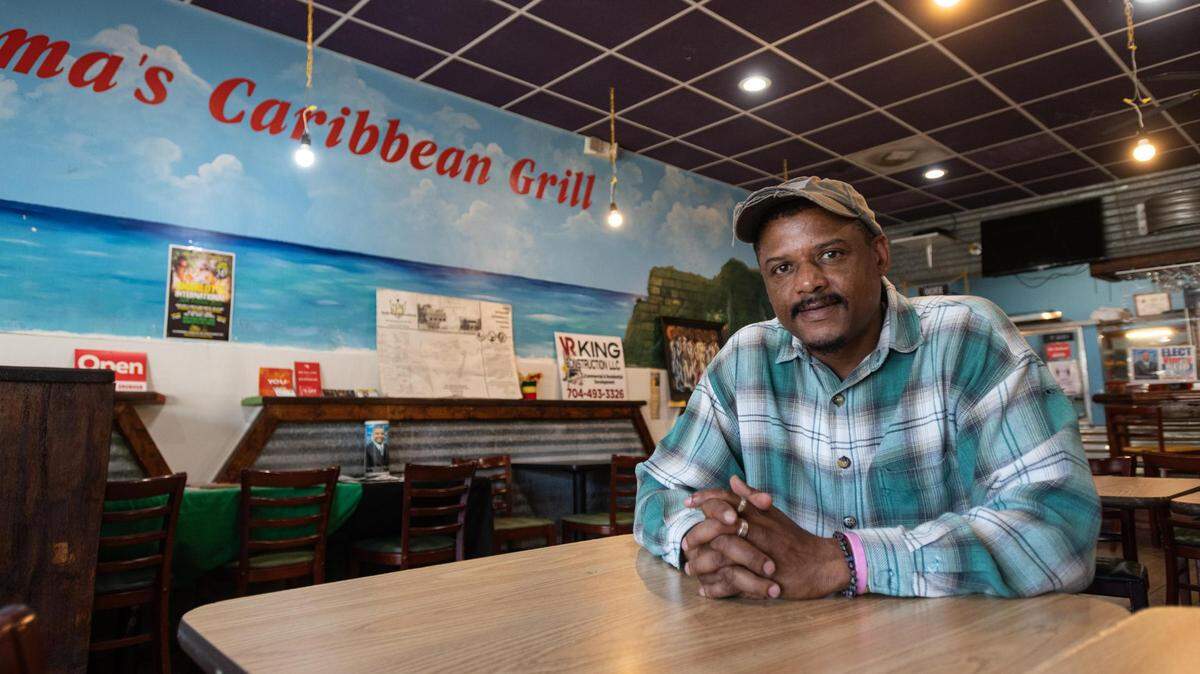 Restaurant owner Vinroy Reid sits for a portrait in the dining room of Mama’s Caribbean Grill at Plaza Midwood in Charlotte, N.C. Wednesday, July 27, 2022.