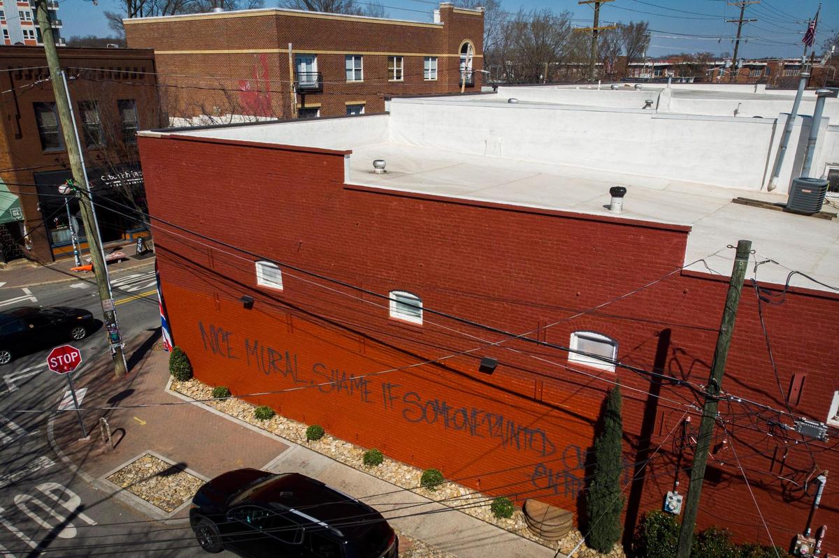A wall at the corner of East 35th Street and North Davidson Street reads “nice mural, shame if someone painted over it” on the site of the former “Bloom” mural by artist Osiris Rain in Charlotte on Thursday, March 3, 2022. The mural was accidentally covered up by a painting crew who was contracted to paint the other side of the building. Rain intends to create a new mural on the wall in the future.
